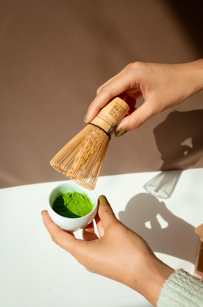 Hand holding the Shinrin Tea Whisk and Shinrin Tea Matcha